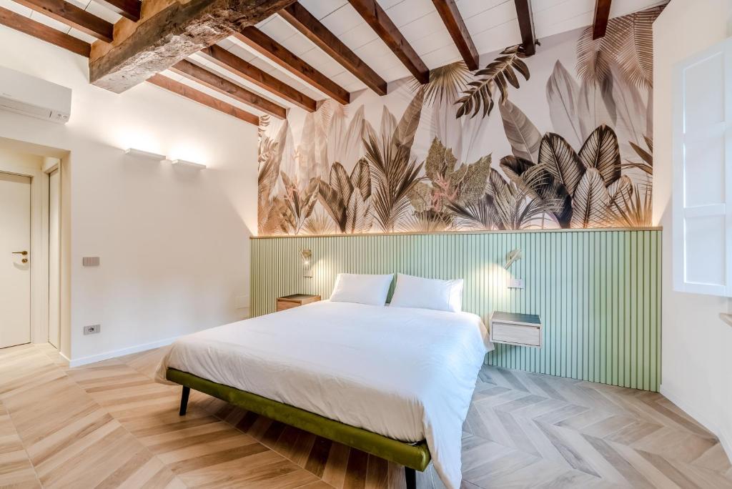 - une chambre avec un lit et une fresque murale de plantes dans l'établissement Parco Ducale Design Rooms, à Parme