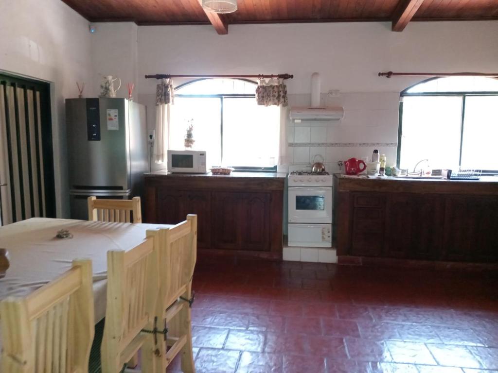 a kitchen with a refrigerator and a table with chairs at La Ilusión in Campos Salles