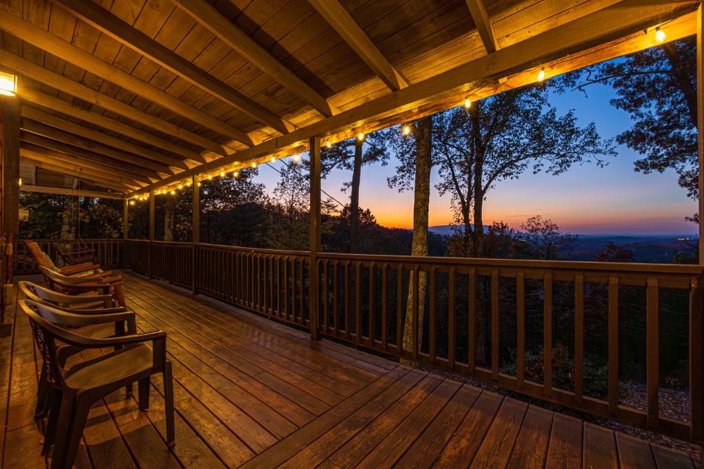 a deck with chairs and a view of the sunset at King Beds, VIEWS, Fire Pit, Spa, No Fees, New, Private, Games in Sevierville