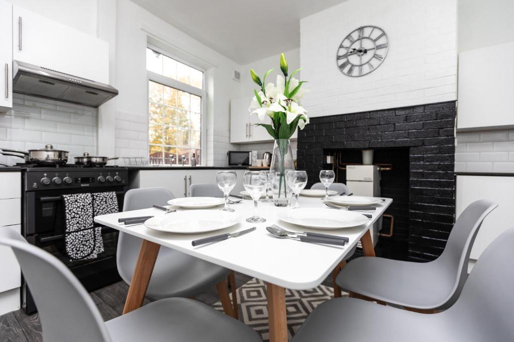una sala da pranzo bianca con tavolo e sedie bianchi di Spacious three bedroom property! a Hemsworth