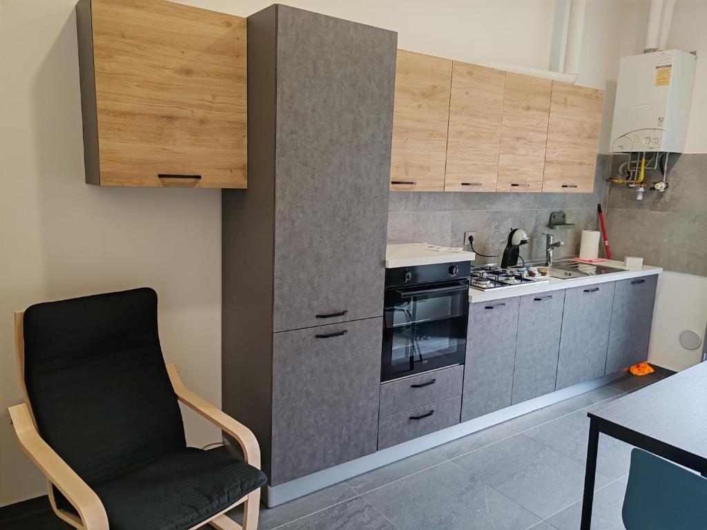 eine Küche mit einem schwarzen Stuhl und einem Herd in der Unterkunft Appartamenti Lungo Fiume 506 in Sesto Calende
