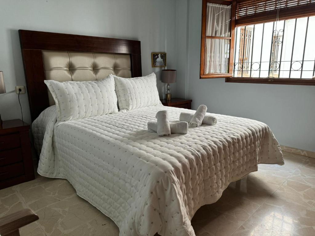 een slaapkamer met een wit bed en 2 handdoeken bij Apartamento Buen Pastor con parking gratuito in Córdoba