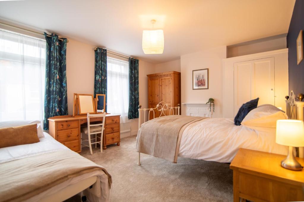 a bedroom with two beds and a desk at Boursault Rose *4 Bed *WiFi *Canterbury in Canterbury