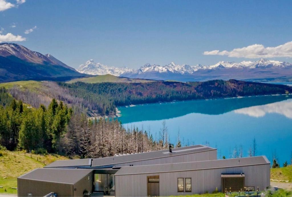 a building with a view of a lake and mountains at Lake Pukaki Lake House in Lake Pukaki