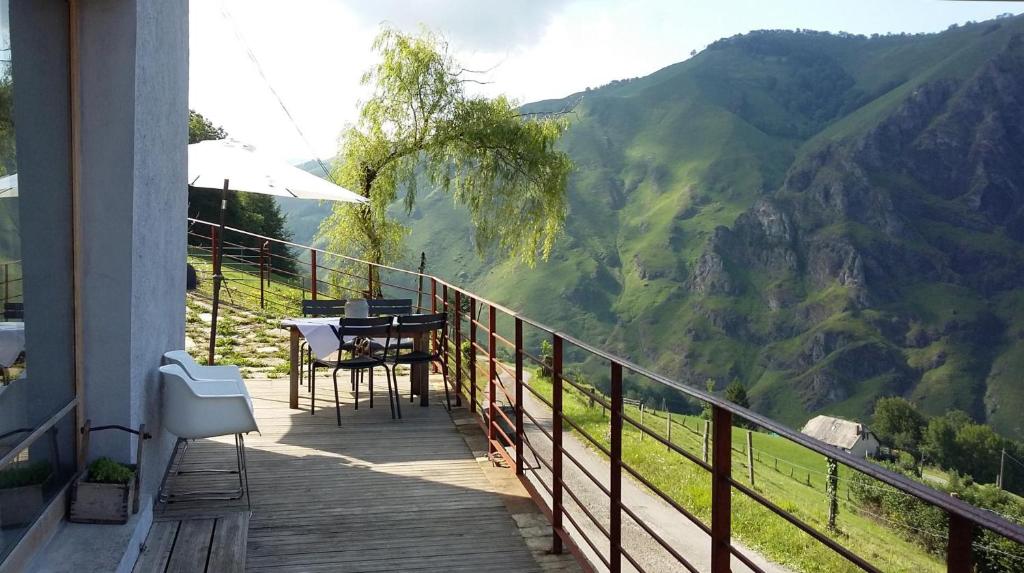 Un balcón de una casa con una mesa y sillas. en Uthurraltia, en Larrau