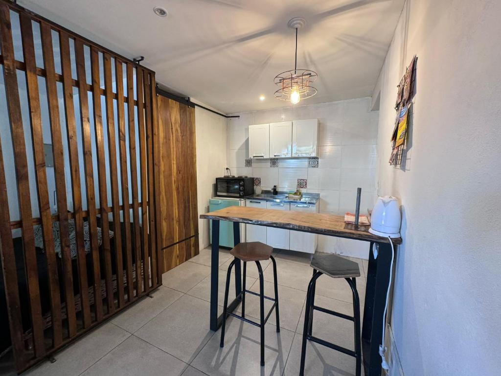 eine Küche mit einer Theke und Hockern in einem Zimmer in der Unterkunft Moderno Monoambiente con estacionamiento in Godoy Cruz