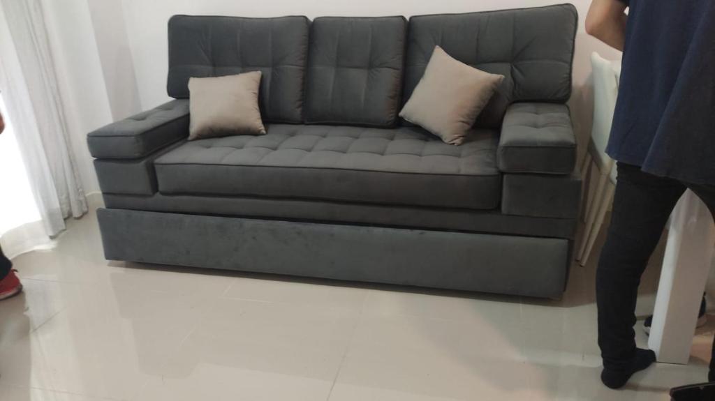 1 sofá gris con 2 almohadas en la sala de estar en Cambacuá Congreso en Buenos Aires