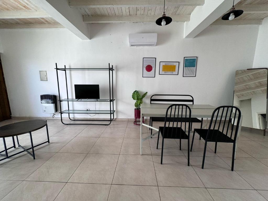 sala de estar con mesa, sillas y TV en Amplio Departamento con estacionamiento en Godoy Cruz