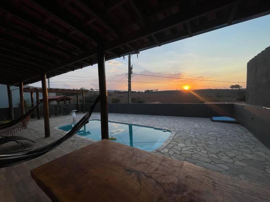 un patio con hamaca y vistas a la puesta de sol en Chácara pôr do sol en Socorro
