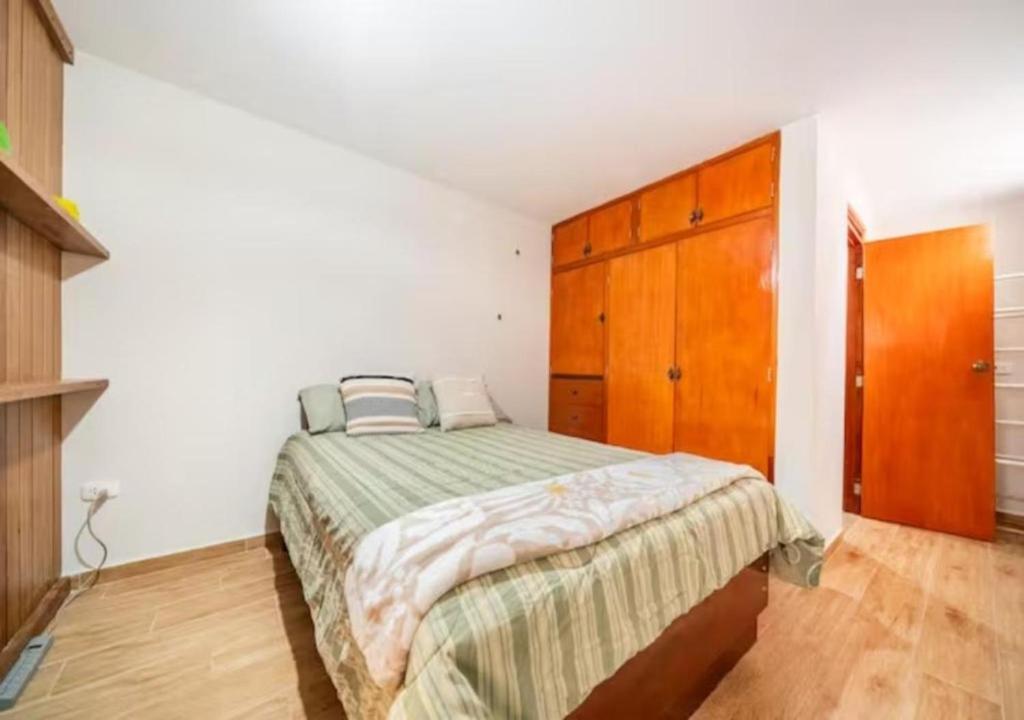 1 dormitorio con 1 cama y armario de madera en Hermoso departamento equipado, en Lima