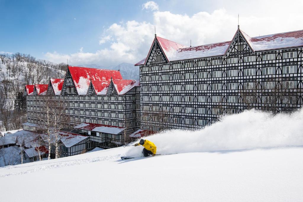 a fire hydrant in the snow in front of a building at Hotel Green Plaza Hakuba in Otari