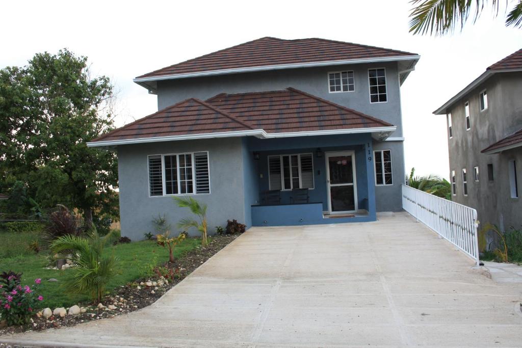 a small white house with a brown roof at Soleil Palm View Villa in Priory