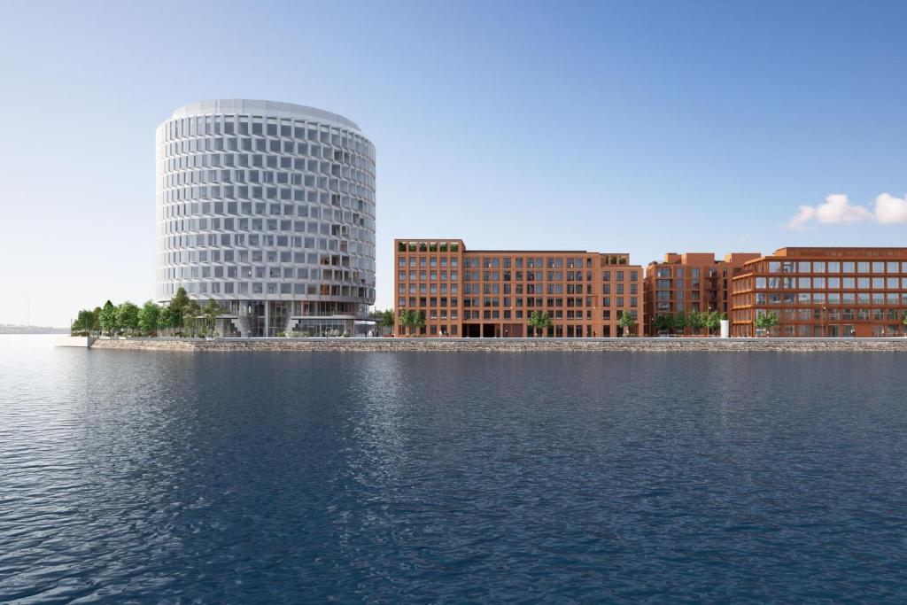 a tall white building next to a body of water at Residence Inn by Marriott Copenhagen Nordhavn in Copenhagen