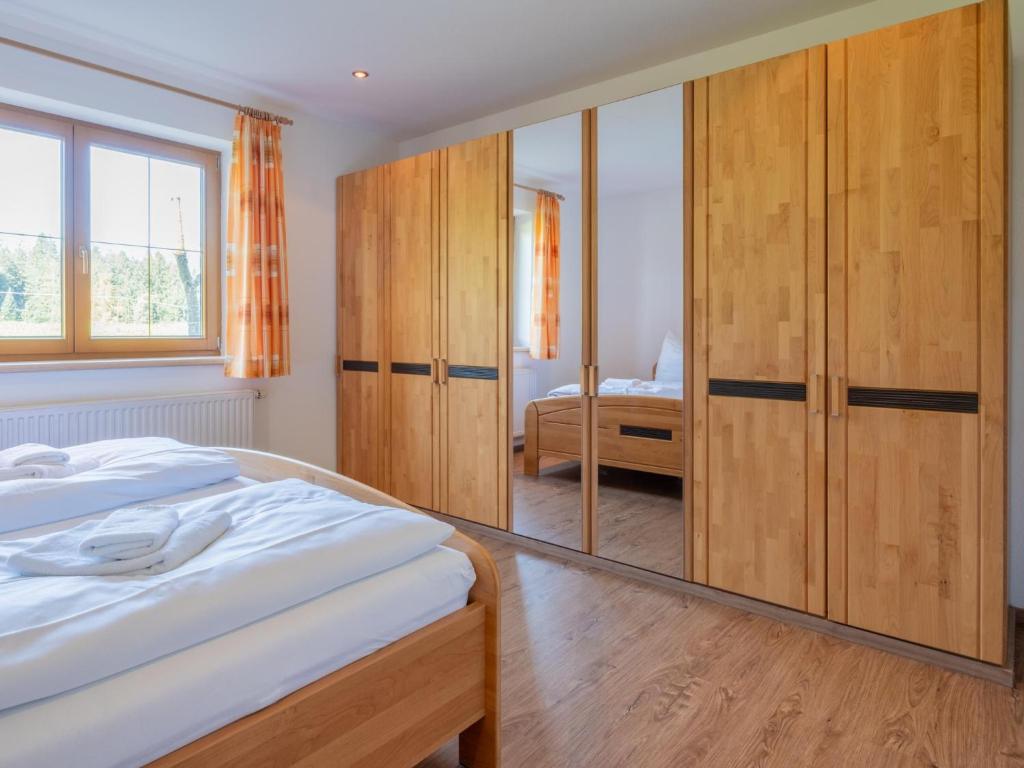 a bedroom with a bed and wooden cabinets and a mirror at Obinghof in Söll
