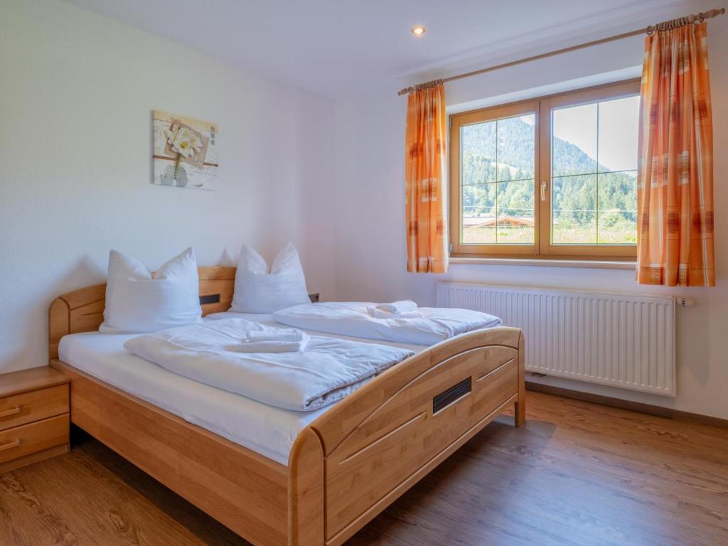 a bed in a room with a large window at Obinghof in Söll