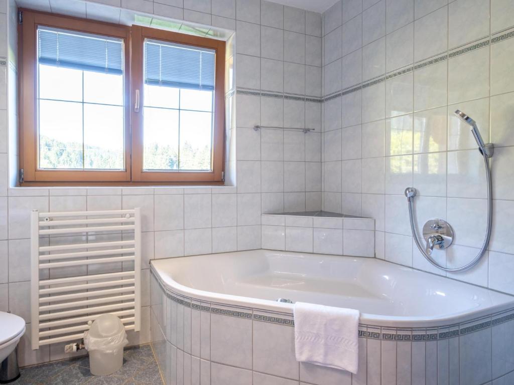 a white bathroom with a tub and a toilet at Obinghof in Söll