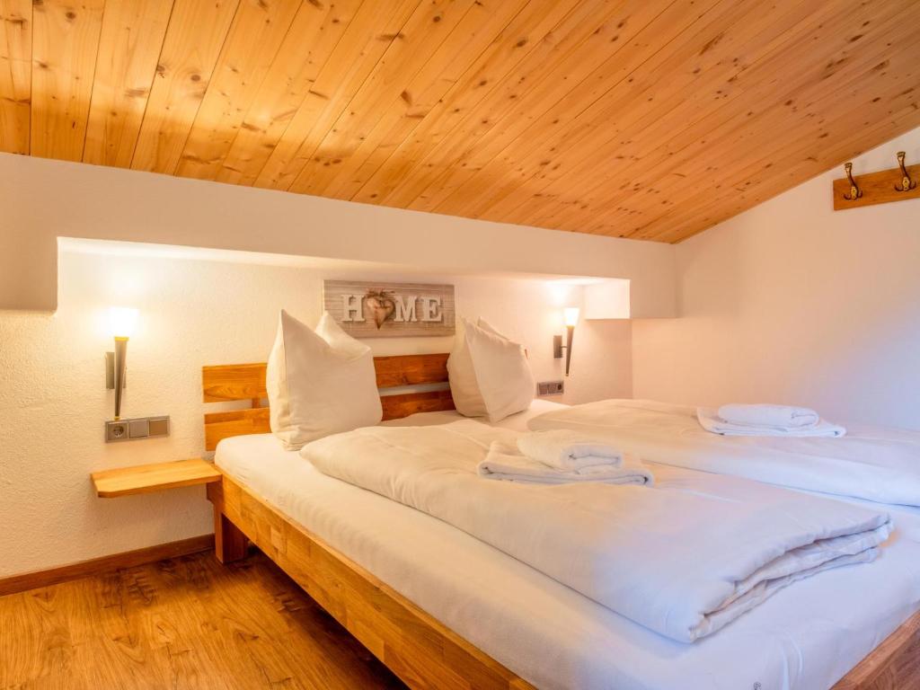 two beds in a room with wooden ceilings at Obinghof in Söll