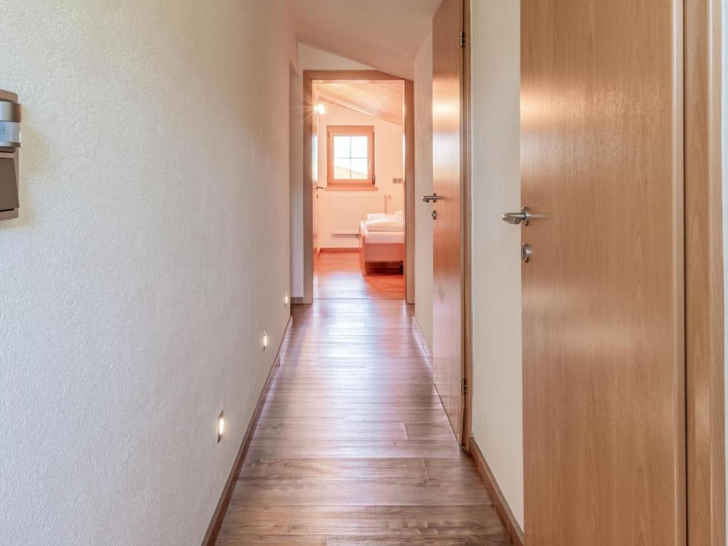 a hallway with white walls and a wooden floor at Obinghof in Söll