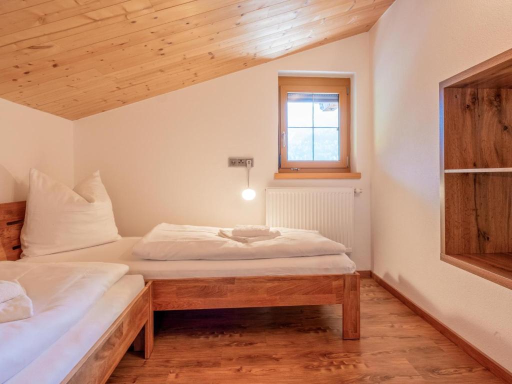 a bedroom with two beds and a window at Obinghof in Söll