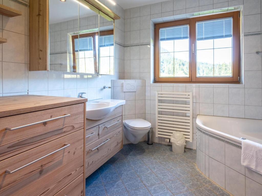 a bathroom with a tub and a toilet and a sink at Obinghof in Söll