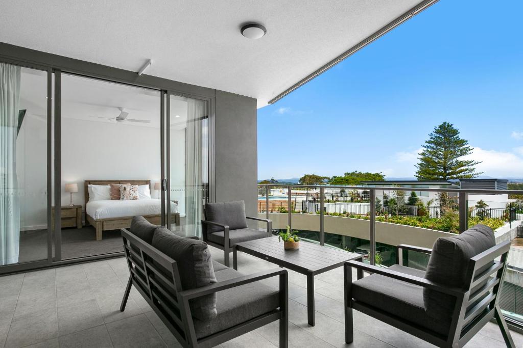 福斯特Solaris 412的客房设有阳台、一张床、一张桌子和椅子