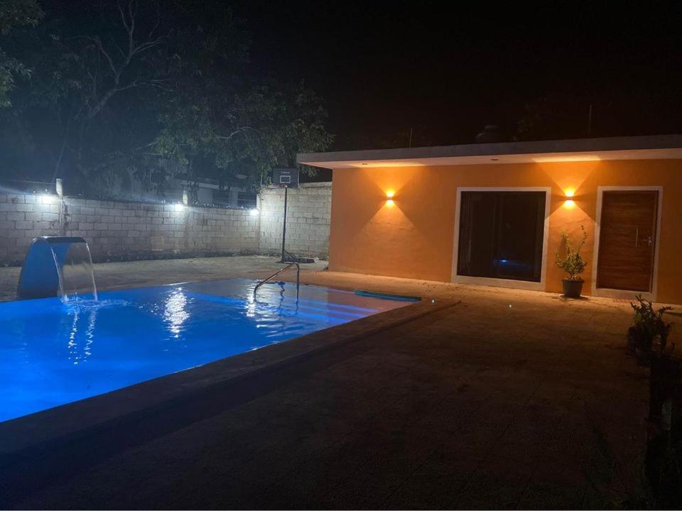 una piscina frente a una casa por la noche en FINCA SAN SEBASTIAN en Tizimín