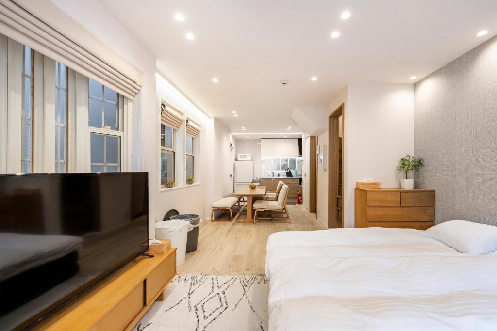 1 dormitorio con 1 cama y TV de pantalla plana en Hotel STAY ARI Higashishinjuku en Tokio