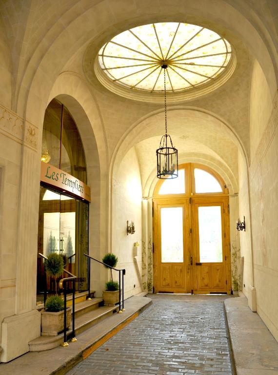 a hallway of a building with a large wooden door at Grand Hôtel Des Templiers in Reims