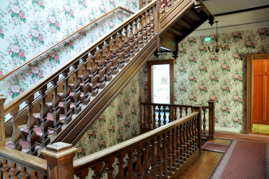 a staircase in a house with floral wallpaper at Grand Hôtel Des Templiers in Reims