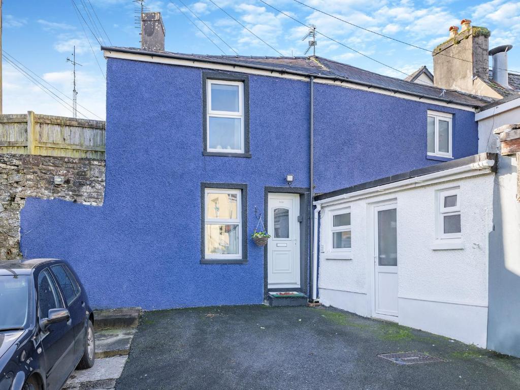 a blue house with a car parked in front of it at The Llandeilo Cottage in Llandeilo