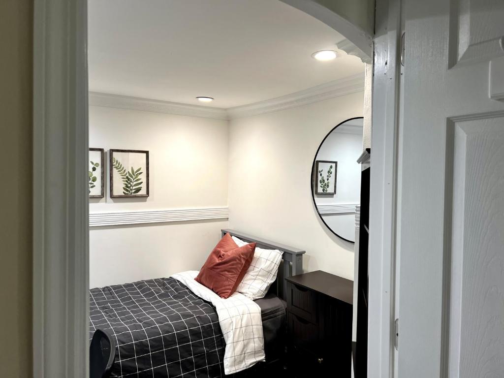 a small bedroom with a bed and a mirror at 6-A Diamond in Yonkers, NY in Yonkers