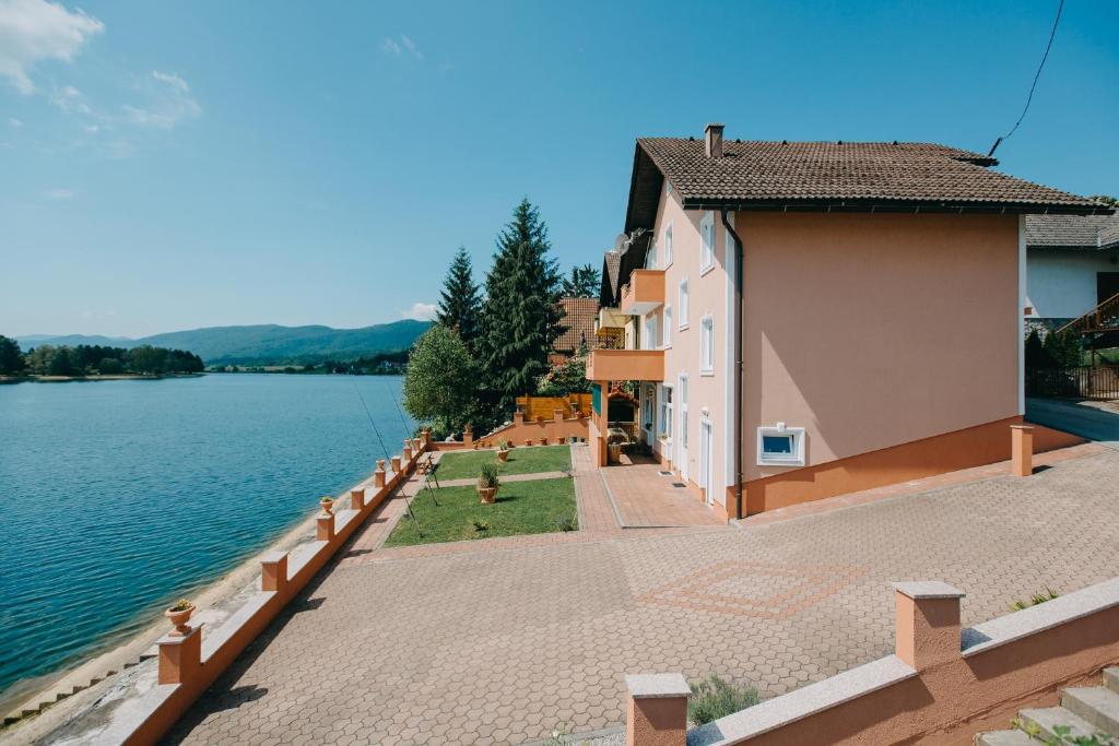 a building next to a body of water at Apartments with a parking space Sabljak Selo, Gorski kotar - 21683 in Ogulin