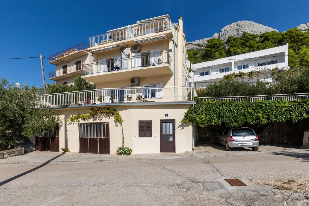 a building with a car parked in front of it at Apartments with parking space Marusici, Omis - 1131 in Mimice