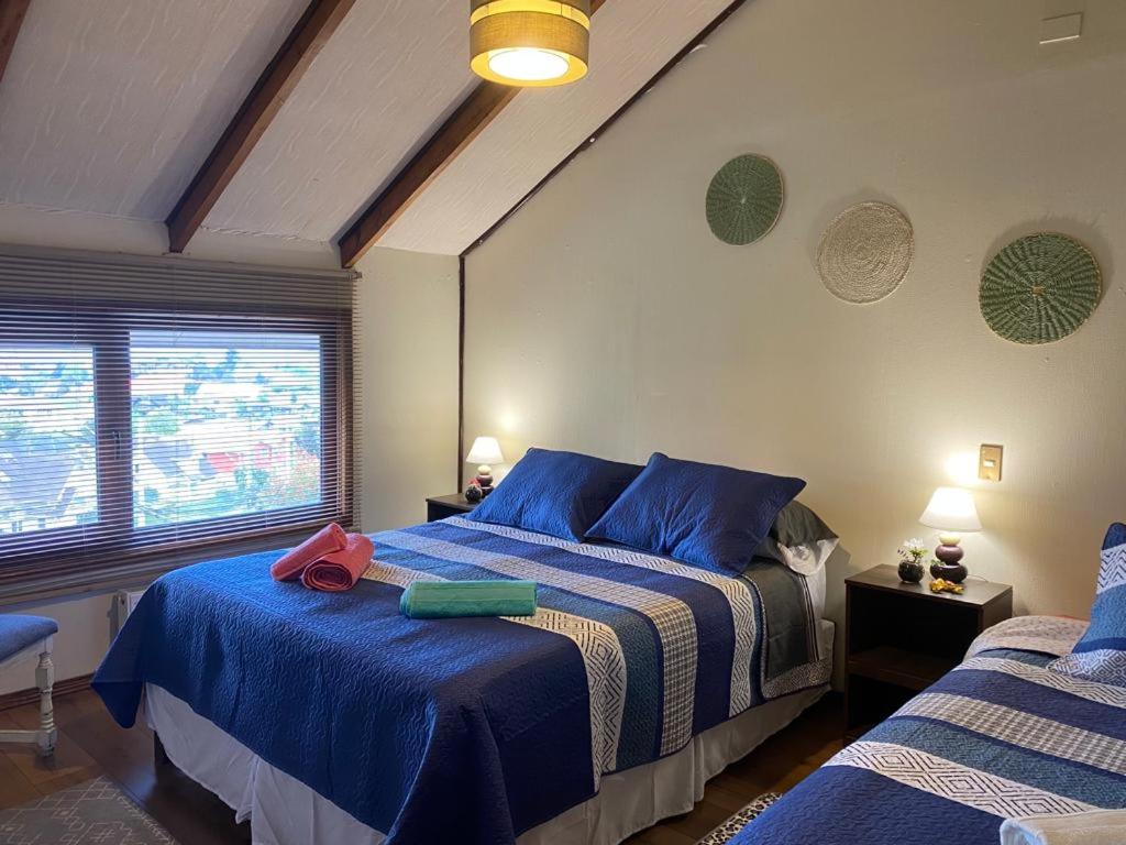 una camera con due letti con lenzuola blu di Felices Sueños, Entre Volcanes . a Puerto Varas