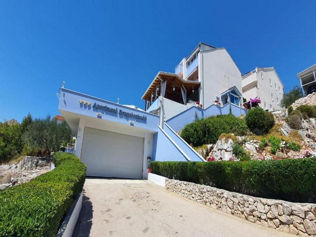 クレックにあるApartments by the sea Komarna, Neretva Delta - Usce Neretve - 21938の坂の脇のガレージ付き家