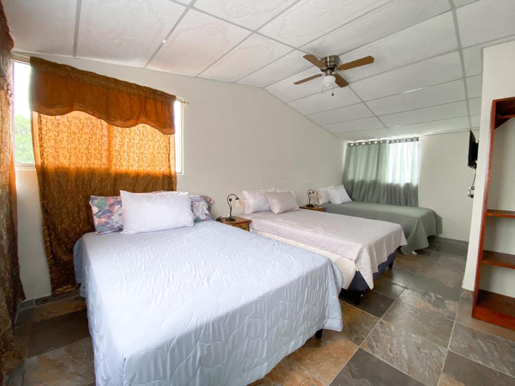 1 dormitorio con 2 camas y ventana en MARIA III HOSTAL en Juayúa