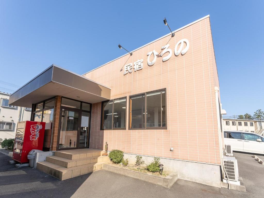 un edificio con un cartel en la parte delantera en Minshuku Hirono, en Ōyauchi