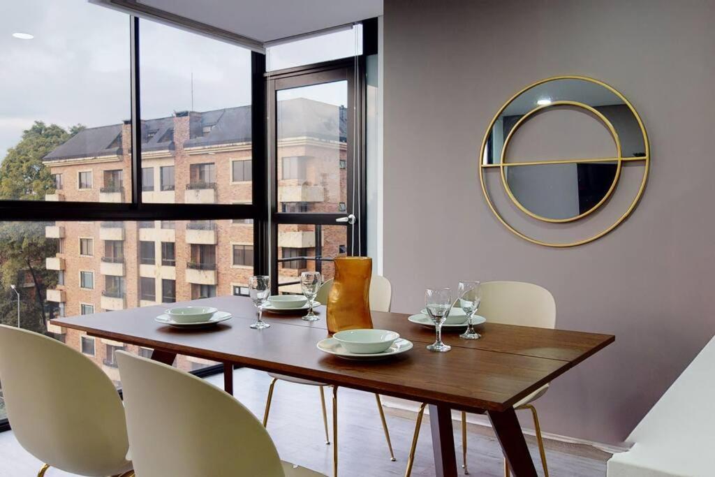 a dining room with a table and chairs and a mirror at Unicentro Delight Norte Bogotá 2 habitaciones in Bogotá