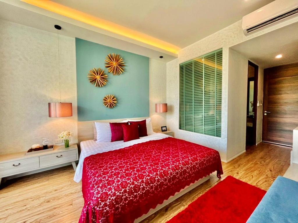 a bedroom with a red bed with a red blanket at Mukrada House Boutique Hometel Krabi in Klong Muang Beach