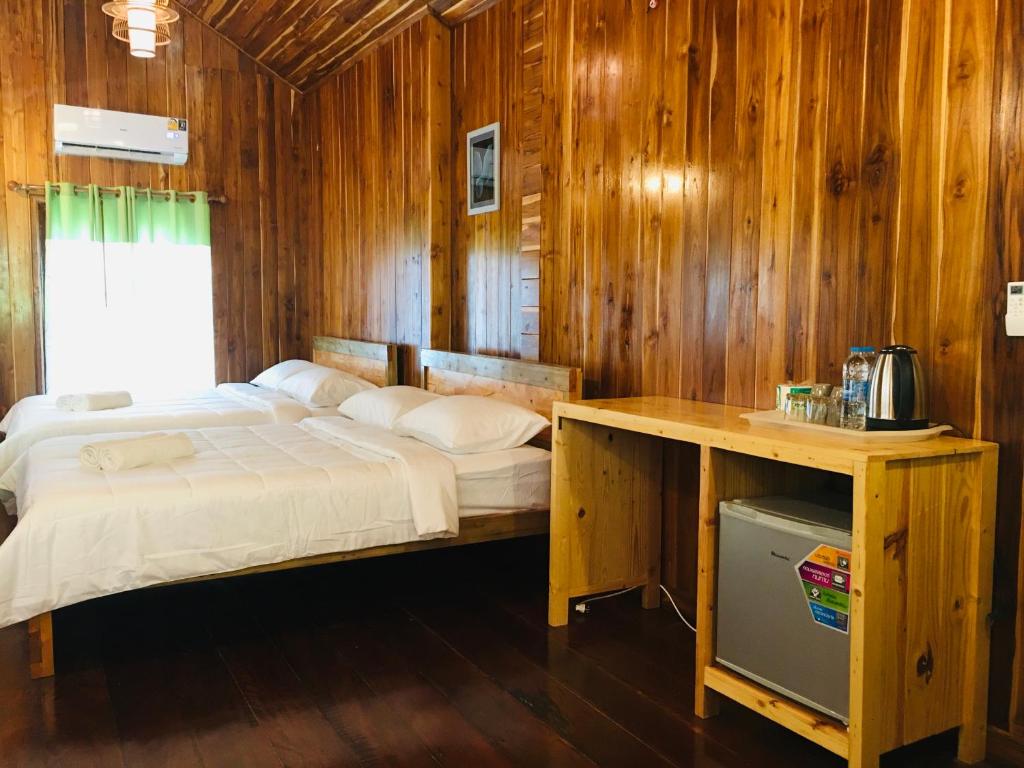 a bedroom with a bed and a wooden wall at Baan Sangchan in Ko Kood