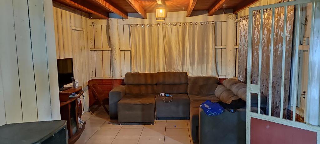 a living room with a couch and a television at Casa de férias e camping in São Félix do Xingu