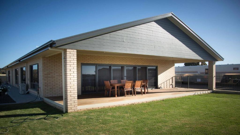 a house with a deck with a table and chairs at Highview on Victoria Coffin Bay in Coffin Bay