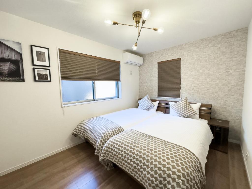 a bedroom with a bed and a window at 大吉屋日赤館 名駅そばの一棟貸し in Nagoya