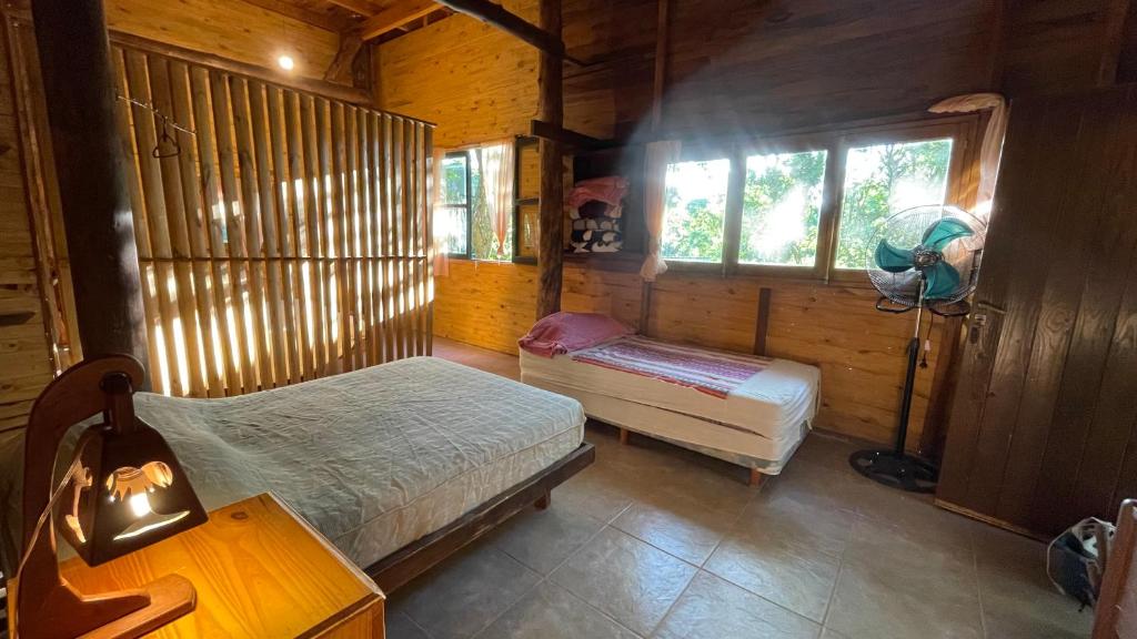 1 Schlafzimmer mit 2 Betten in einer Holzhütte in der Unterkunft Casa Barranca del Mbocay in Puerto Iguazú