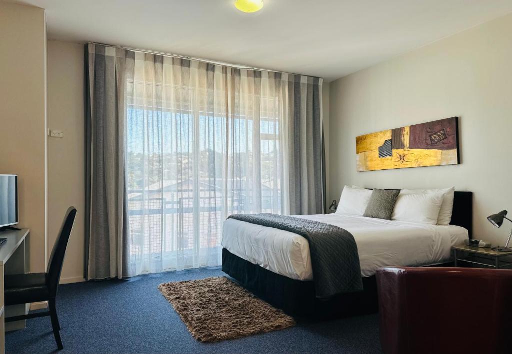 a hotel room with a bed and a large window at Best Western Wellington in Johnsonville