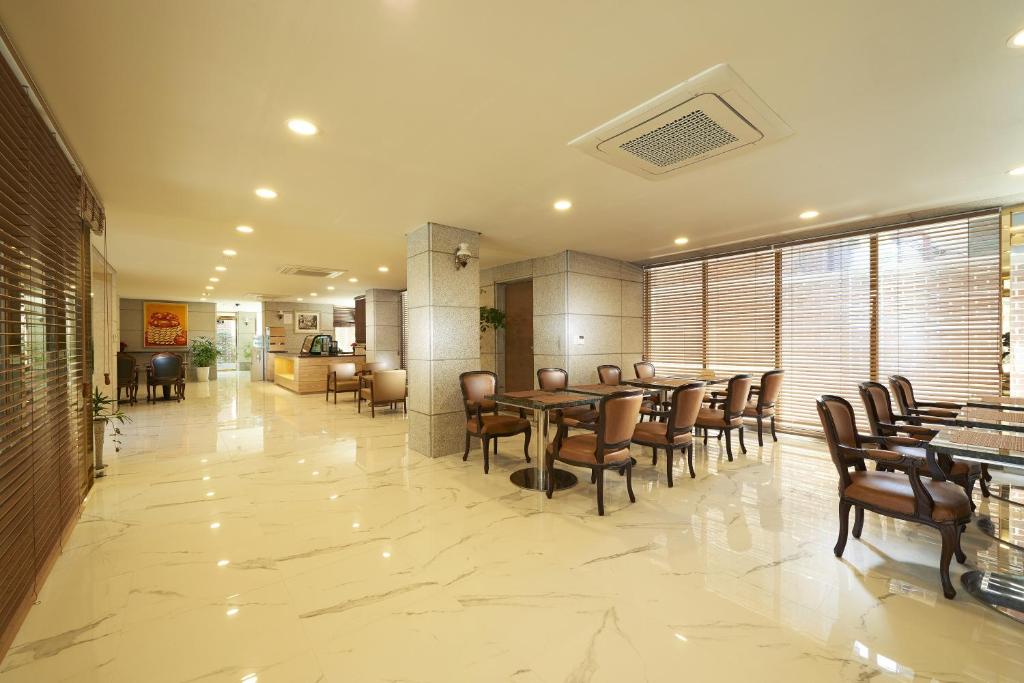 首爾的住宿－豪門酒店，一间在房间内配有桌椅的餐厅
