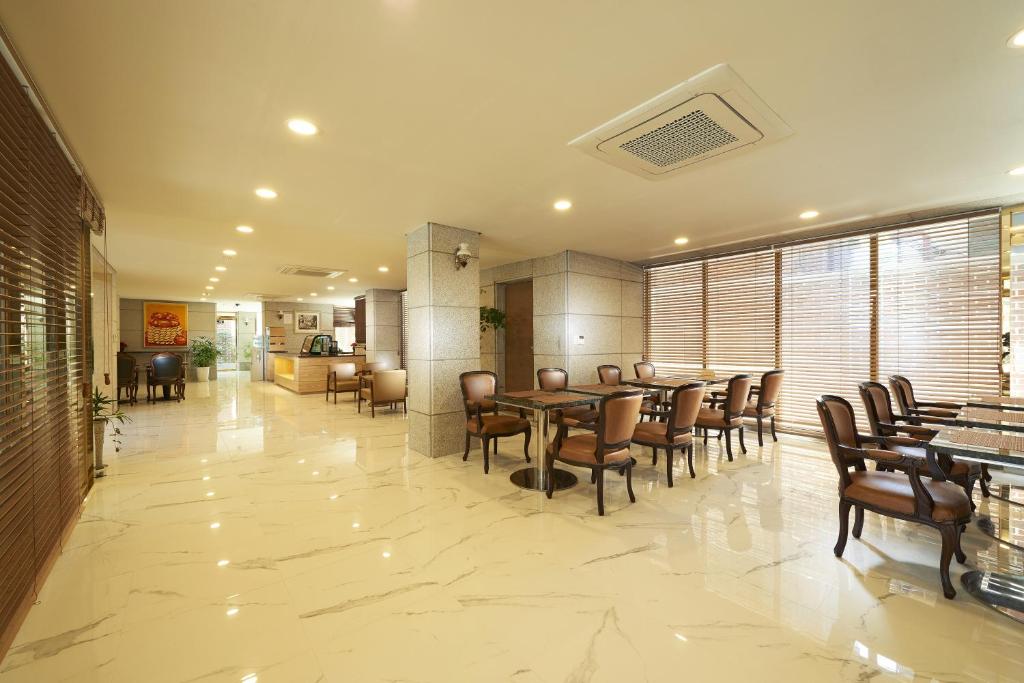 a restaurant with tables and chairs in a room at Noble Hotel in Seoul