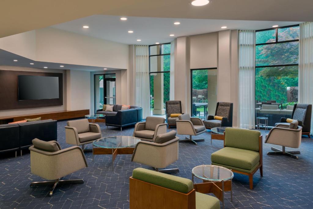 a waiting room with chairs and tables and a tv at Courtyard by Marriott Danbury in Danbury