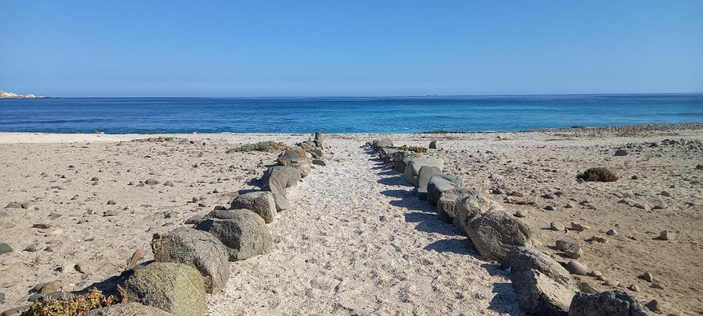 a row of rocks on a beach next to the ocean at Cabañas Alma Changa Atacama in Caldera