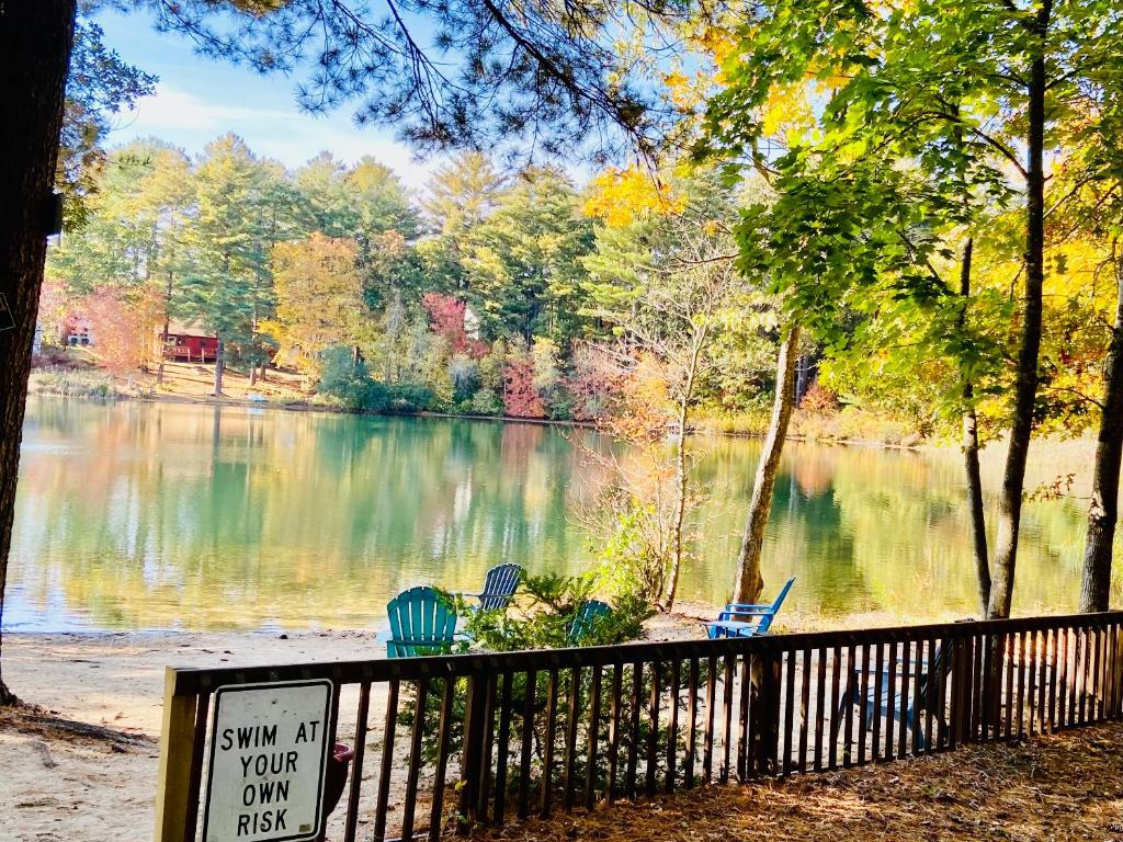 un cartel frente a un lago con sillas en Clear Pond Suite, en Plymouth
